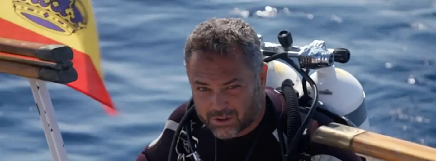 Karlos Simón en el agua con el equipo de buceo, junto a la bandera de España, en la serie Hundidos